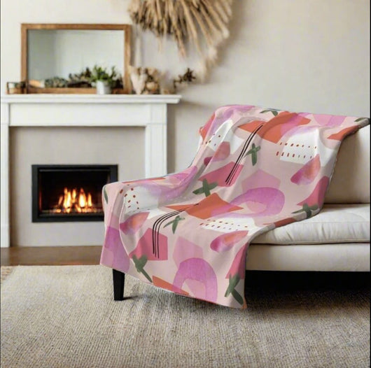 Pink and green throw blanket with abstract pattern