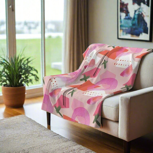 Modern pink and green fleece throw blanket in minimalistic room