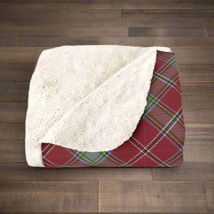 red plaid fleece throw blanket on wooden floor close up