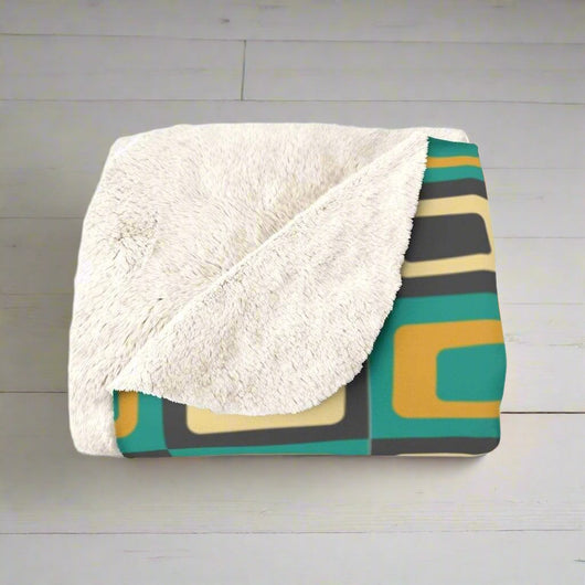 Teal and Gold Sherpa Fleece Blanket on a grey floor